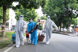 Các nhân viên y tế tại khu cách ly tập trung của Trung đoàn 834 hỗ trợ người dân sau khi trở về Vĩnh Phúc. (Ảnh: Hoàng Hùng/TTXVN)