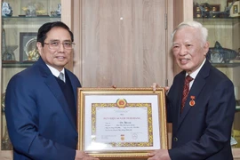 Thủ tướng Phạm Minh Chính trao Huy hiệu 60 năm tuổi Đảng tặng ông Vũ Khoan. (Ảnh: TTXVN phát)