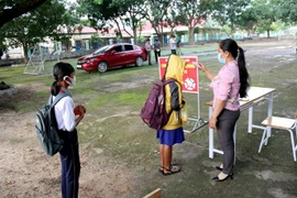 Các em học sinh Trường Tiểu học và Trung học cơ sở Đông Tiến (xã Đông Tiến, (Hàm Thuận Bắc, Bình Thuận) đi học trở lại. (Ảnh: Nguyễn Thanh/TTXVN)