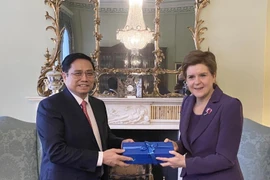 Thủ hiến Vùng Scotland Nicola Sturgeon tặng quà lưu niệm Thủ tướng Phạm Minh Chính. (Ảnh: Dương Giang/TTXVN)