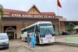 Tiếp nhận và kiểm tra thân nhiệt cho các lưu học sinh Lào tại cửa khẩu quốc tế Bờ Y, tỉnh Kon Tum ngày 16/10/2020 để đưa về cách ly. (Ảnh: TTXVN phá)