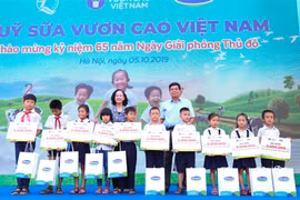 Bà Trương Thị Mai - Ủy viên Bộ Chính trị, Bí thư Trung ương Đảng, Trưởng ban Dân vận Trung ương cùng đại biểu khách mời trao học bổng và sữa của Quỹ Sữa Vươn Cao Việt Nam cho các em học sinh khó khăn có thành tích học tập tốt của trường Tiểu học Tiên Dược