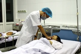 Bác sỹ thăm khám cho chị Nguyễn Thị Thanh Nhàn. (Ảnh: Tá Chuyên/TTXVN)