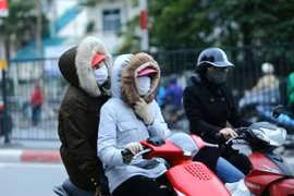 Người dân Hà Nội trang bị áo ấm chống rét, trên đường Giải Phóng (Hà Nội). (Ảnh: Danh Lam/TTXVN)