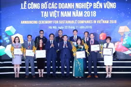 Phó Thủ tướng Chính phủ Vương Đình Huệ và Chủ tịch VCCI Vũ Tiến Lộc trao chứng nhận cho các doanh nghiệp 3 năm liền nằm trong top 10 doanh nghiệp bền vững. (Ảnh: Minh Quyết/TTXVN)