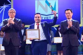 Bộ trưởng Bộ Thông tin và Truyền thông Nguyễn Mạnh Hùng (bên phải) và giáo sư, viện sỹ Đặng Vũ Minh trao giải cho các tác giả có sản phẩm đạt giải tại hạng mục Ứng dụng công nghệ số xuất sắc. (Ảnh: Minh Quyết/TTXVN)