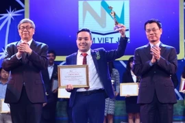 Bộ trưởng Bộ Thông tin và Truyền thông Nguyễn Mạnh Hùng (bên phải) và giáo sư, viện sỹ Đặng Vũ Minh trao giải cho các tác giả có sản phẩm đạt giải tại hạng mục Ứng dụng công nghệ số xuất sắc. (Ảnh: Minh Quyết/TTXVN)