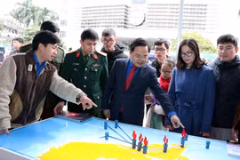 Bí thư Thường trực Trung ương Đoàn Nguyễn Anh Tuấn với các đại biểu thăm các gian hàng tại triển lãm. (Ảnh: Văn Điệp/TTXVN)