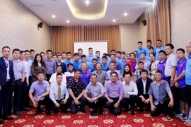 Đại sứ Nguyễn Bá Hùng cùng chụp ảnh lưu niệm với Ban huấn luyện và các cầu thủ đội tuyển Việt Nam. (Ảnh: Phạm Kiên/Vietnam+)