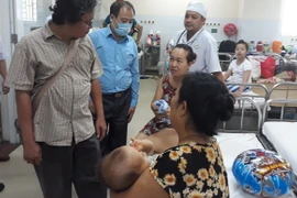Đoàn làm việc của Cục Y tế dự phòng (Bộ Y tế) thăm hỏi các bệnh nhi tại Bệnh viện Nhi đồng Đồng Nai. (Ảnh: TTXVN/Vietnam+)