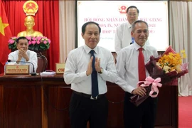 Ông Lê Tiến Châu, Chủ tịch UBND tỉnh Hậu Giang (bên trái) tặng hoa cho ông Lữ Văn Hùng. (Ảnh: Duy Khương/TTXVN)
