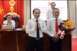 Ông Lê Tiến Châu, Chủ tịch UBND tỉnh Hậu Giang (bên trái) tặng hoa cho ông Lữ Văn Hùng. (Ảnh: Duy Khương/TTXVN)