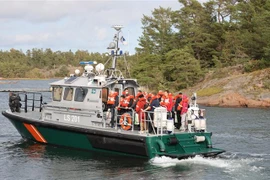 Hành khách được sơ tán từ phà bị mắc cạn tại một đảo trên biển Baltic. (Ảnh: AFP/TTXVN)