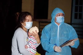 Hướng dẫn công dân làm thủ tục vào khu cách ly. (Ảnh: Thanh Hải/TTXVN)