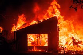 Một tòa nhà bốc cháy dữ dội do cháy rừng lan rộng tại St. Helena, bang California, Mỹ. (Ảnh: AFP/TTXVN)