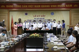 Quyền Bộ trưởng Bộ Y tế Nguyễn Thanh Long và Tổng Giám đốc Bảo hiểm xã hội Việt Nam Nguyễn Thế Mạnh ký kết biên bản ghi nhớ. (Ảnh: TTXVN)