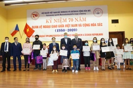 Trao phần thưởng cho các cháu học sinh. (Ảnh: Hồng Kỳ/Vietnam+)