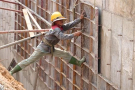 Công nhân thi công đang hoàn thiện hệ thống thoát nước Khu tái định cư Lộc An-Bình Sơn. (Ảnh: Công Phong/TTXVN)