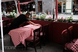 Nhân viên sửa soạn lại bàn ghế tại một nhà hàng ở New York, Mỹ. (Ảnh: AFP/TTXVN)