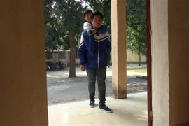 Em Ngô Minh Hiếu đã thay đôi chân đưa người bạn khuyết tật Nguyễn Tất Minh hàng ngày đến trường. (Ảnh: Khiếu Tư/TTXVN)