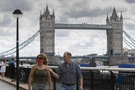 Người dân di chuyển trên đường phố tại London, Anh. (Ảnh: THX/TTXVN)