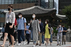 Người dân đeo khẩu trang phòng lây nhiễm COVID-19 tại Seoul, Hàn Quốc. (Ảnh: AFP/TTXVN)