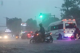 Các phương tiện tham gia giao thông gặp khó khăn do mưa lớn. (Ảnh: Nguyễn Oanh/TTXVN)