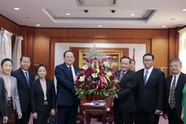 Phó Thủ tướng Sonexay đang trao hoa cho Đại sứ Nguyễn Bá Hùng, chúc mừng 75 năm quốc khánh Việt Nam. (Ảnh: Phạm Kiên/Vietnam+)