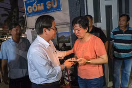 Chủ tịch UBND thành phố Cần Thơ Trần Việt Trường thăm hỏi, trao tiền hỗ trợ cho đại diện Cơ sở sửa chữa, mua bán phụ tùng ôtô Kim Thu. (Ảnh: Thanh Liêm/TTXVN)