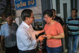 Chủ tịch UBND thành phố Cần Thơ Trần Việt Trường thăm hỏi, trao tiền hỗ trợ cho đại diện Cơ sở sửa chữa, mua bán phụ tùng ôtô Kim Thu. (Ảnh: Thanh Liêm/TTXVN)