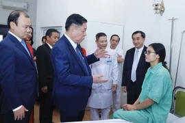 Trưởng Ban Tuyên giáo Trung ương Nguyễn Trọng Nghĩa thăm hỏi, tặng quà cho bệnh nhân đang điều trị tại Bệnh viện Thể thao Việt Nam. (Ảnh: Minh Quyết/TTXVN)