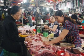 Khách mua thịt lợn tại chợ Phường 5, thành phố Đông Hà, Quảng Trị. (Ảnh: Thanh Thủy/TTXVN)