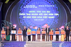 Thủ tướng Nguyễn Xuân Phúc trao quà cho đồng bào các dân tộc sống và sinh hoạt tại Làng Văn hóa-Du lịch các dân tộc Việt Nam. (Ảnh: Thống Nhất/ TTXVN)