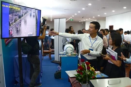 Các đại biểu tham quan các gian hàng trưng bày sản phẩm công nghệ số. (Ảnh: Quốc Dũng/TTXVN)