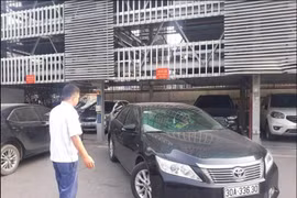Nhân viên điểm trông giữ xe của Công ty trách nhiệm hữu hạn Một Thành Viên Khai Thác Điểm Đỗ Xe Hà Nội hướng dẫn xe ra vào điểm đỗ xe lắp ghép. (Ảnh: Tuyết Mai/TTXVN)