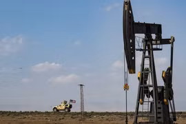 Xe quân sự của Mỹ di chuyển qua một trạm bơm dầu ở thành phố Qamishli, Đông Bắc Syria ngày 26/10/2019. (Nguồn: AFP/TTXVN)