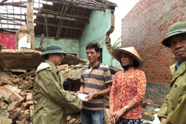 Ông Hồ Quốc Dũng, Chủ tịch Ủy ban Nhân dân tỉnh Bình Định thăm hỏi, động viên và hỗ trợ bước đầu cho các hộ dân bị sập nhà ở xã Phước Thắng (huyện Tuy Phước) khắc phục hậu quả. (Ảnh: Nguyên Linh/TTXVN)