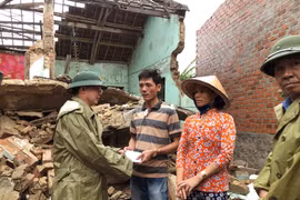 Ông Hồ Quốc Dũng, Chủ tịch Ủy ban Nhân dân tỉnh Bình Định thăm hỏi, động viên và hỗ trợ bước đầu cho các hộ dân bị sập nhà ở xã Phước Thắng (huyện Tuy Phước) khắc phục hậu quả. (Ảnh: Nguyên Linh/TTXVN)