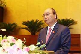 Thủ tướng Nguyễn Xuân Phúc đọc báo cáo của Chính phủ. (Ảnh: Trọng Đức/TTXVN)