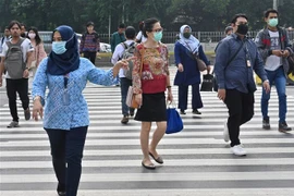 Người dân đeo khẩu trang phòng lây nhiễm COVID-19 tại Jakarta, Indonesia, ngày 19/3/2020. (Ảnh: AFP/TTXVN)