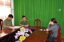 Chị L.T.K.X nhận quyết định xử phạt tại cơ quan Công an huyện Kiên Lương. (Ảnh: TTXVN phát)