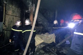 Lực lượng chức năng đã tiếp cận được nạn nhân trong vụ cháy. (Ảnh: Công Tường/TTXVN)