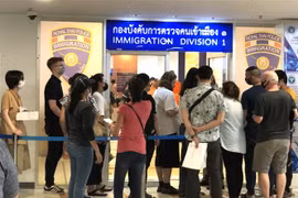 Nhiều người nước ngoài xếp hàng bên ngoài văn phòng Cục Di trú Thái Lan ở Bangkok để xin gia hạn thị thực nhập cảnh ngày 23/3. (Ảnh: Ngọc Quang/TTXVN)