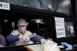 Cửa hàng bánh bao dùng ván gỗ đưa hàng cho khách. (Ảnh: Reuters)