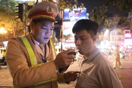 Cảnh sát giao thông kiểm tra nồng độ cồn tại ngã tư Lạc Trung-Thanh Nhàn. (Ảnh: Doãn Tấn/TTXVN)