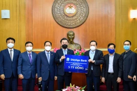 Ông Trần Thanh Mẫn tiếp nhận sự ủng hộ của Ngân hàng Shinhan Bank. (Ảnh: Dương Giang/TTXVN)