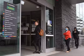 Người dân xếp hàng bên ngoài trung tâm trợ cấp ở Melbourne. (Ảnh: AFP/ TTXVN)
