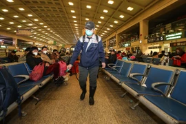 Nhân viên y tế phun thuốc khử trùng tại một nhà ga ở Trung Quốc. (Ảnh: AFP/TTXVN)