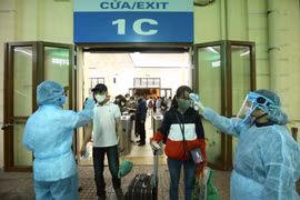 Kiểm tra thân nhiệt cho hành khách tại Ga Hà Nội. (Ảnh: TTXVN)