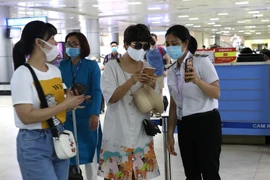 Nhân viên mặt đất kiểm tra mã khai báo y tế hành khách tại sân bay. (Ảnh: Ngọc Hà/TTXVN)